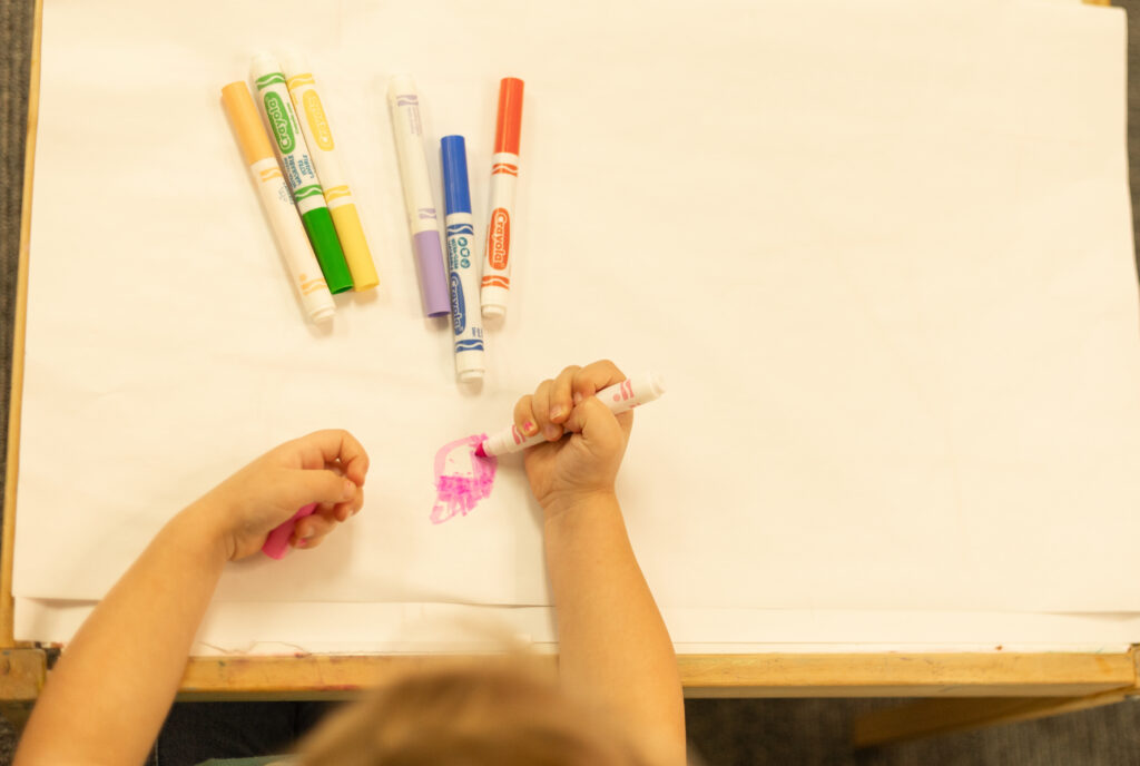 Child drawing with markers